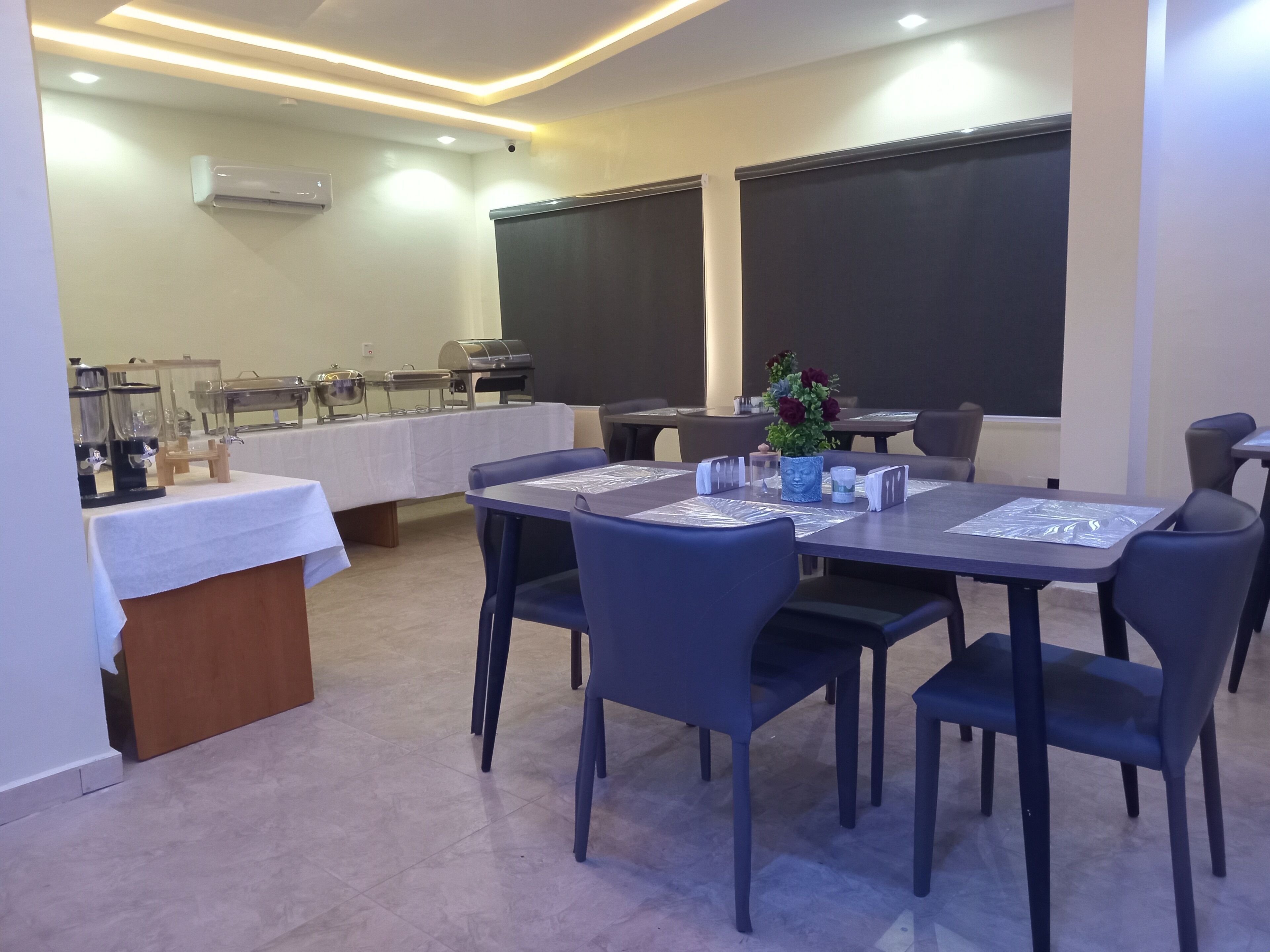 A conference room with a table set for a meeting, a coffee station, and a blackboard on the wall.