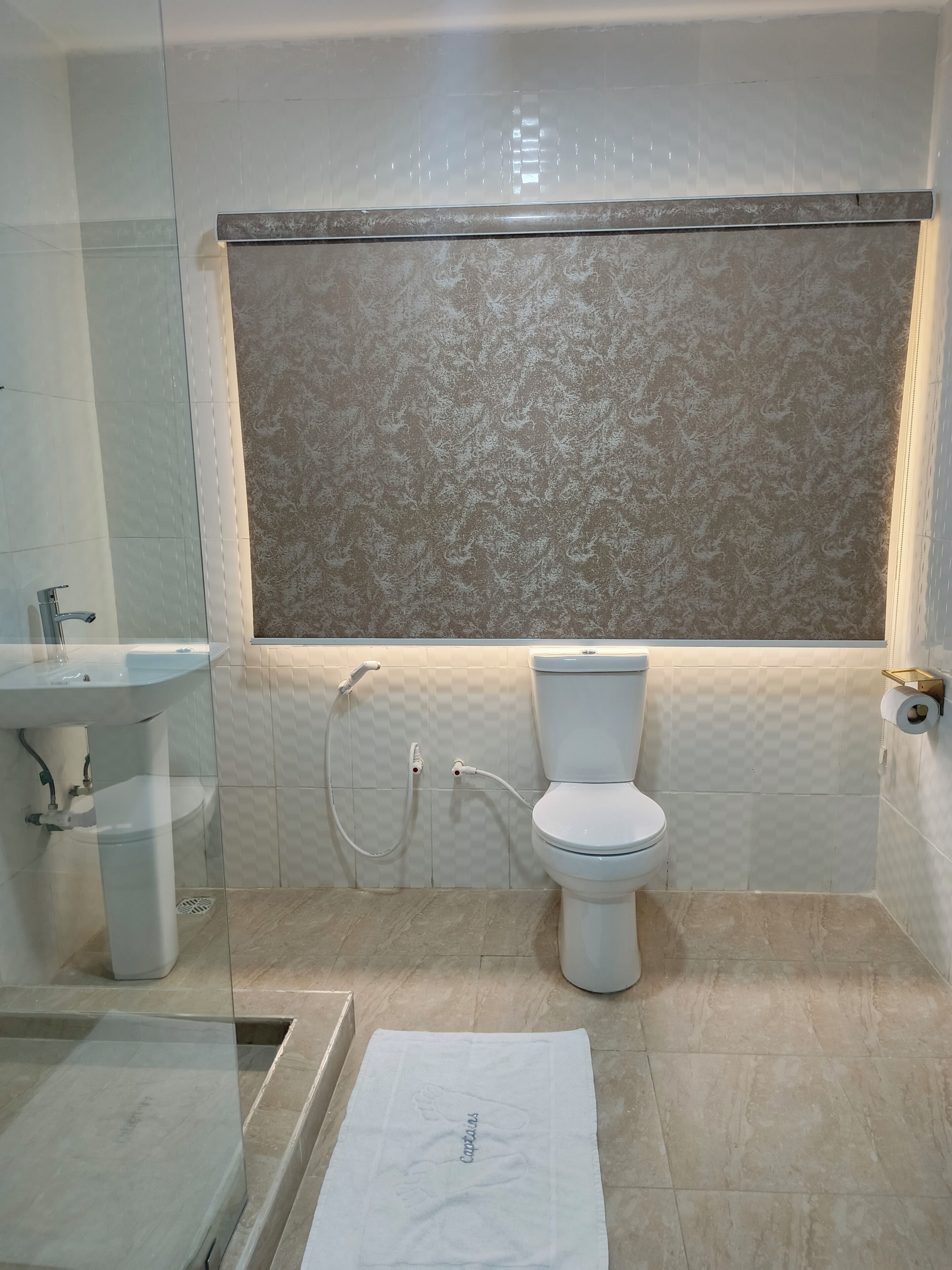 Un baño con inodoro, bidé y lavamanos.