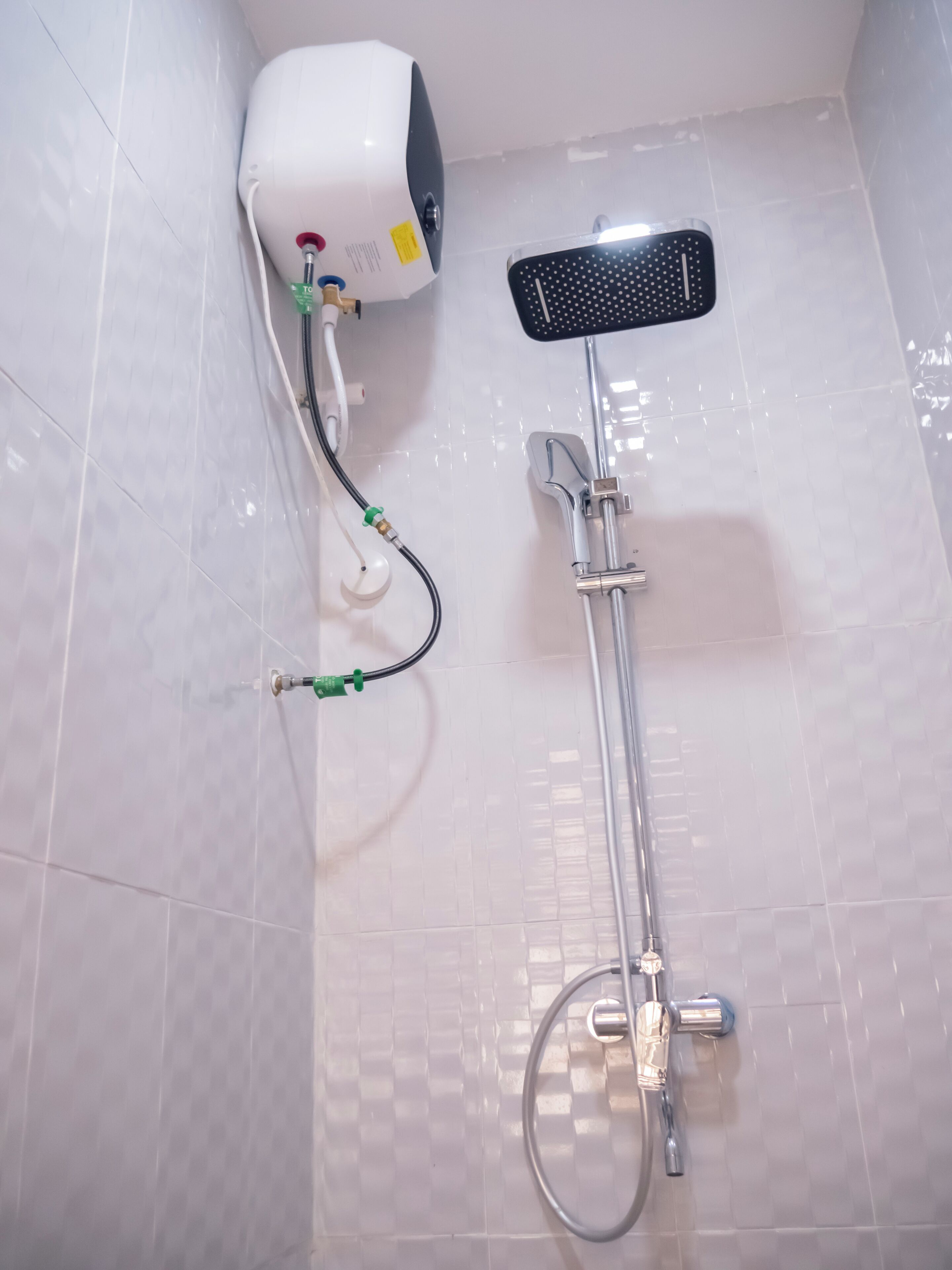 Una ducha con cabezal de ducha de mano, grifo empotrado en la pared y panel de control.