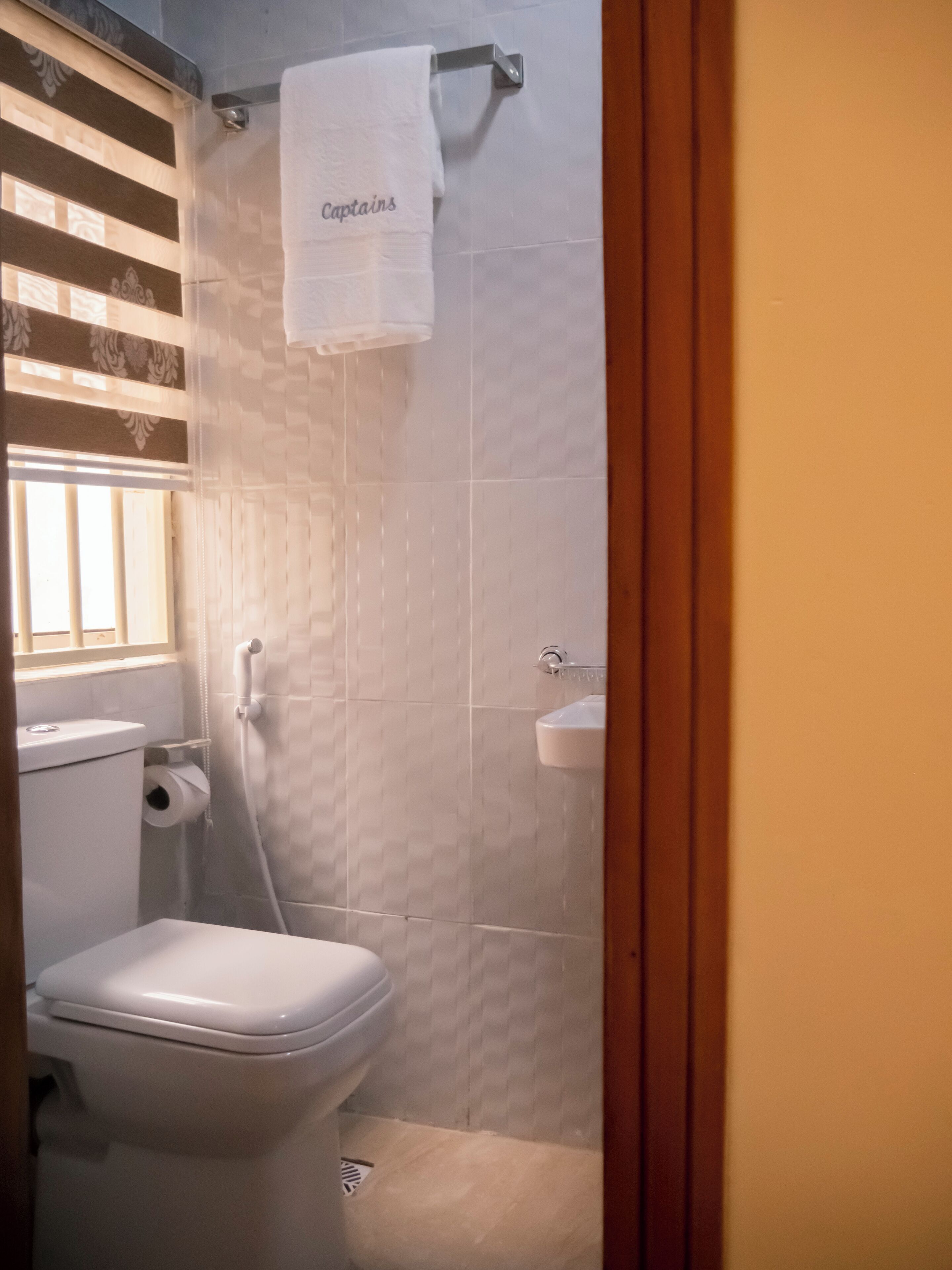 A bathroom with a toilet, a shower, and a sink.