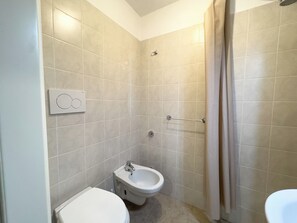 Een douche, een haardroger, een bidet, handdoeken