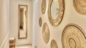 Un couloir orné de plusieurs œuvres d’art murales en fibres tissées et d’un grand miroir.