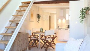 Un intérieur moderne comprenant un escalier, un coin repas et une cuisine.