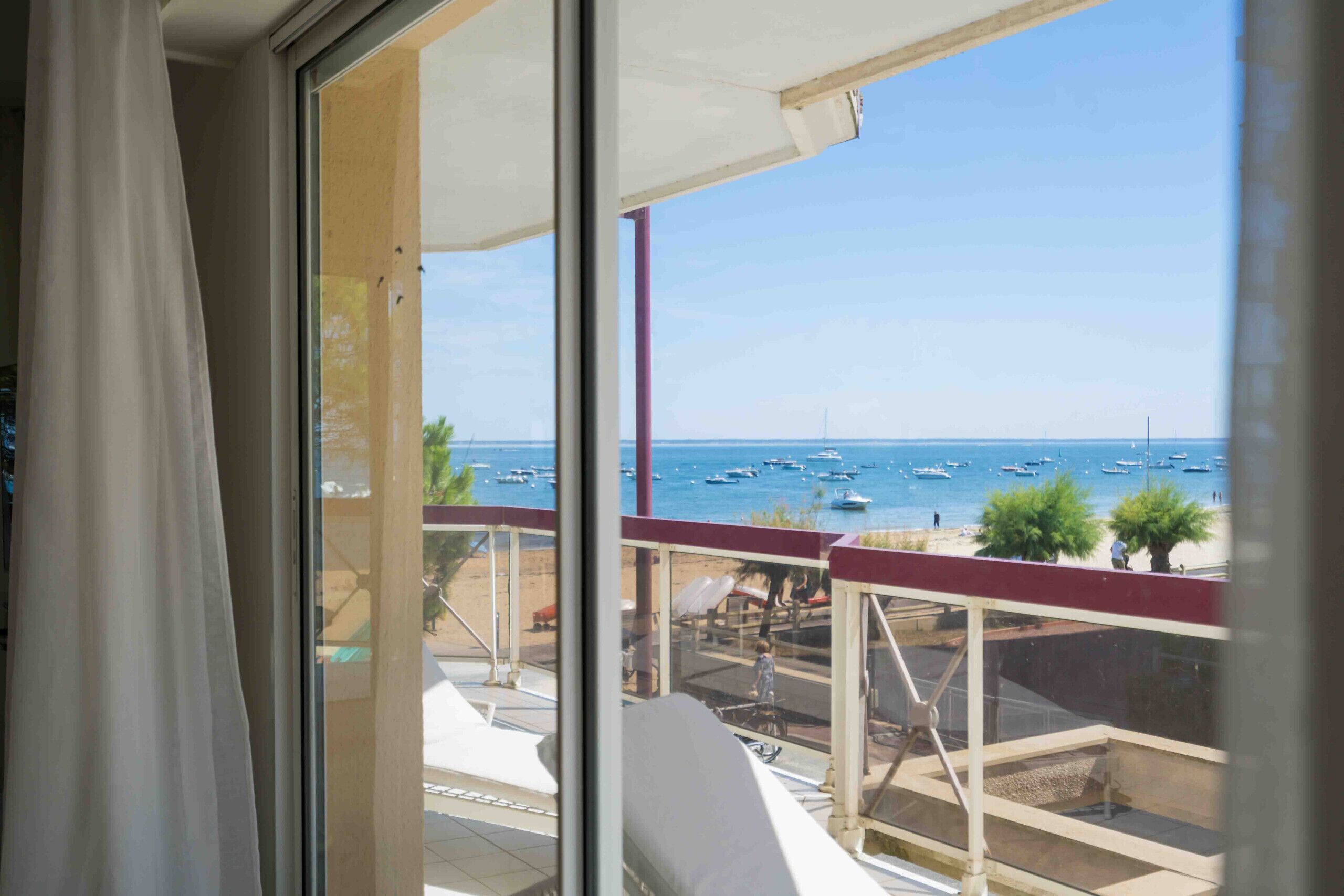 Een balkon met uitzicht op zee en boten.