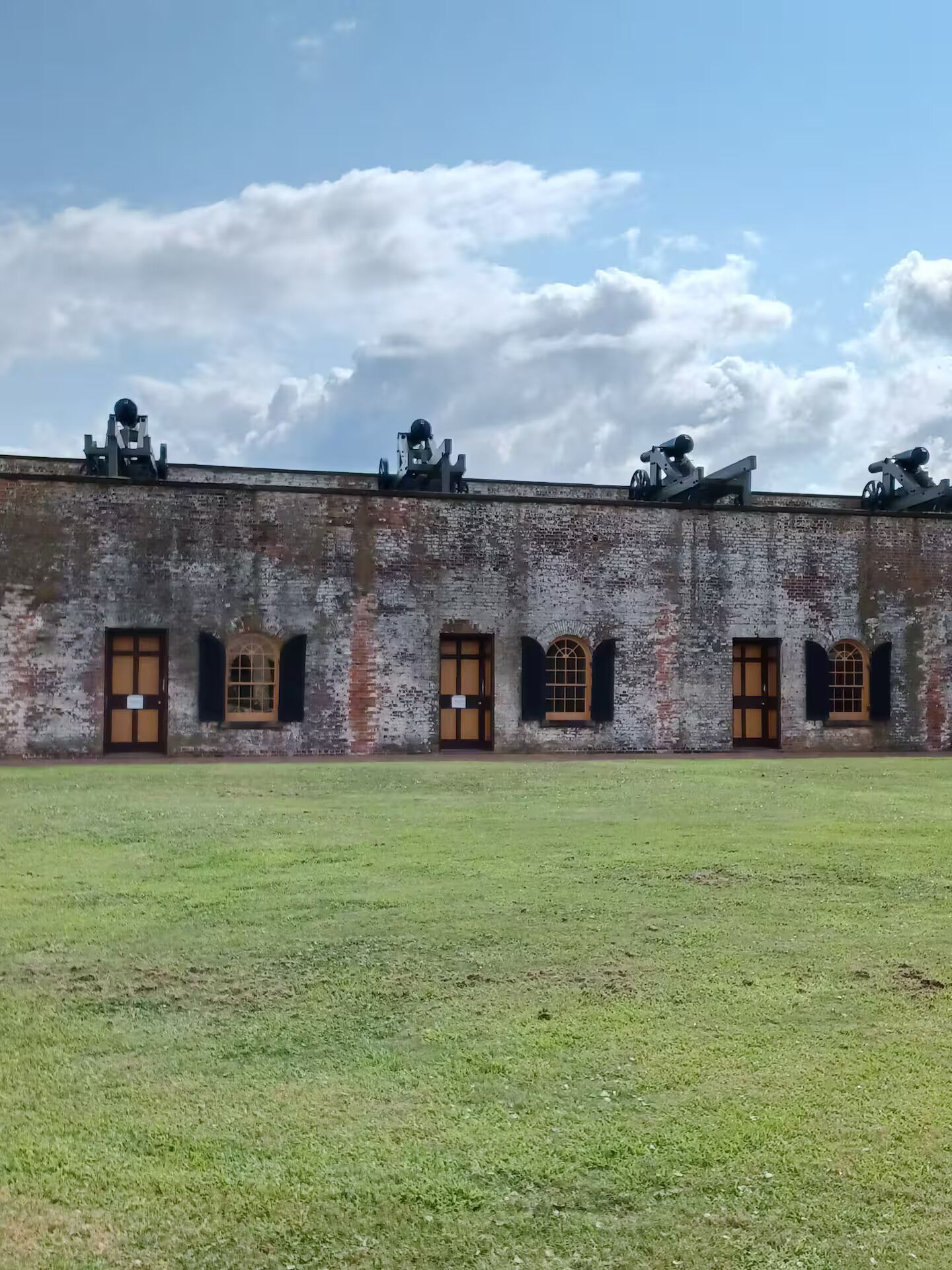 Historiallinen rakennus, jossa on tiiliverhous, useita kaarevia ikkunoita ja tasakatto.
