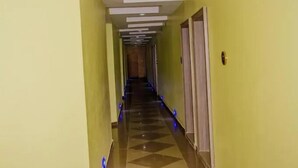 Un pasillo de hotel con piso a cuadros, iluminación empotrada y puertas a ambos lados.