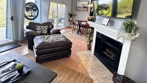 A spacious living room with a fireplace, a large TV, and a comfortable seating area.