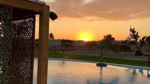 Una piscina con cubierta de madera y una pérgola.