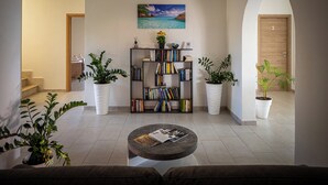 Una sala de estar moderna con una estantería, una mesa de centro y plantas en macetas.