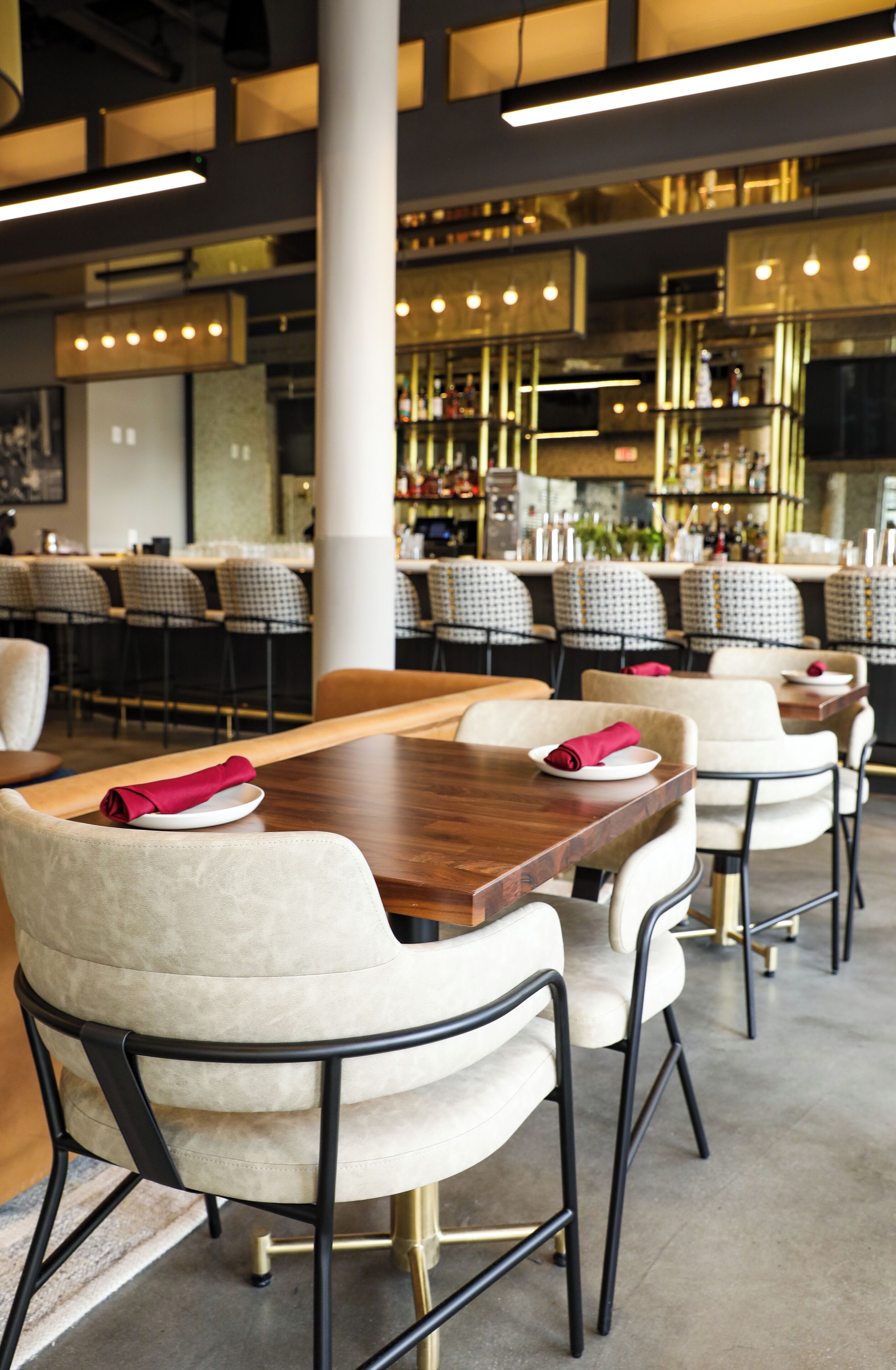 L'intérieur d'un restaurant, avec plusieurs tables, des chaises et un coin bar.