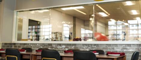 A dining area with tables, chairs, and a large mirror reflecting the interior.