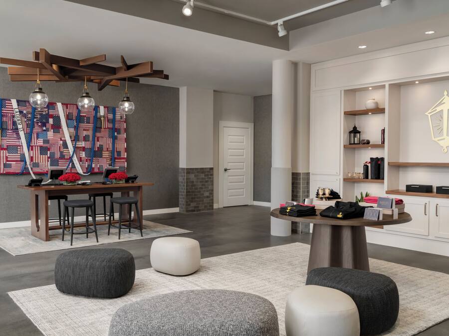 Ein modernes Interieur mit Essbereich, Poufs, einer Wanddekoration und einem kleinen Tisch mit Gegenständen.