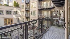 Un immeuble résidentiel à plusieurs étages, doté de balcons, d’une cour intérieure et d’une entrée sécurisée par un portail.
