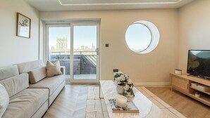 A modern living room with a sofa, coffee table, and TV. - 1 Bed Flat - Sleeps 2 - Parking - Wifi (Dorchester)