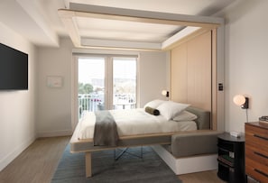 Una camera da letto moderna con un letto, comodini, una TV e una finestra con vista sulla città.