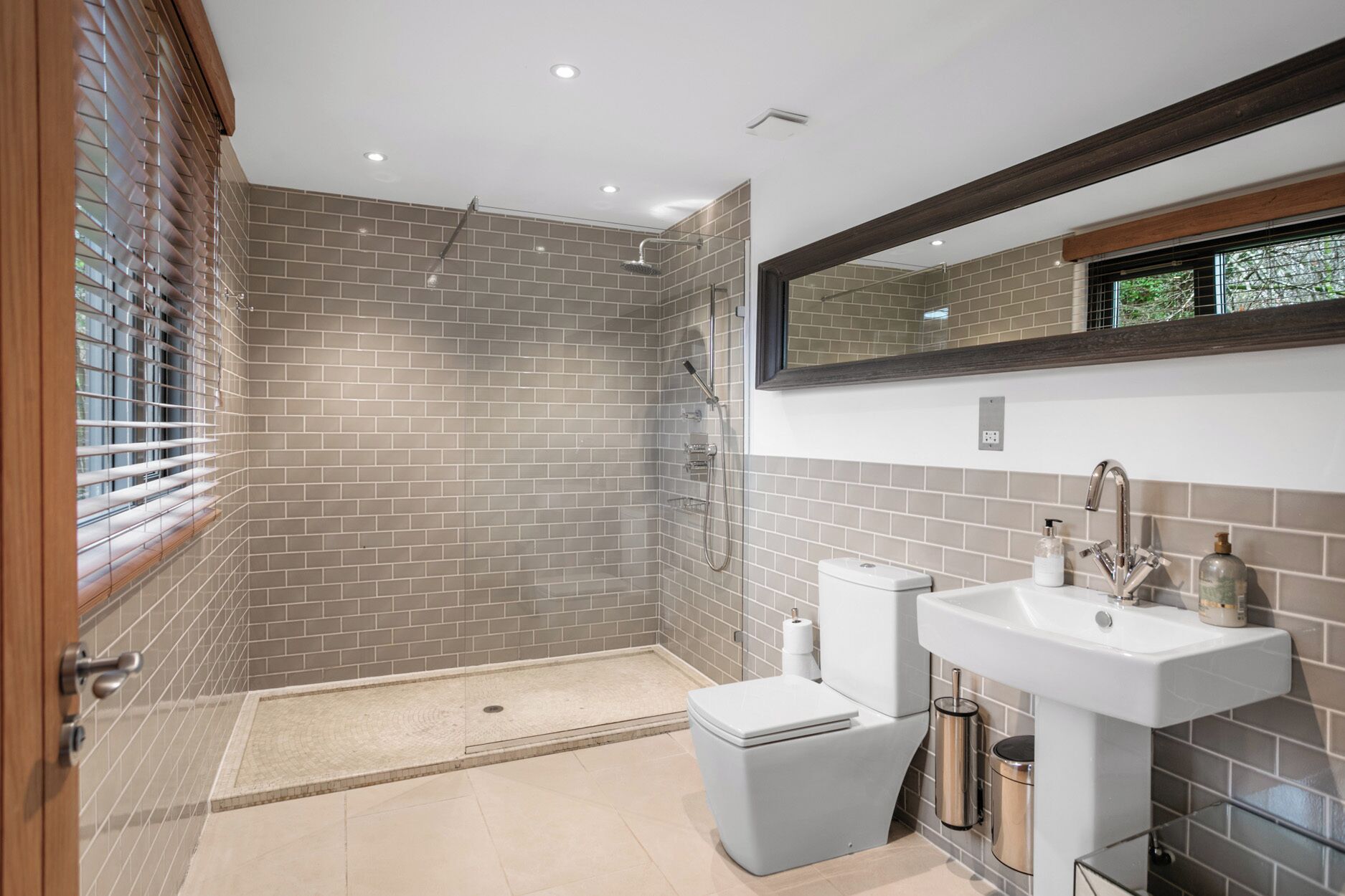 Un baño moderno con ducha, inodoro y lavamanos.