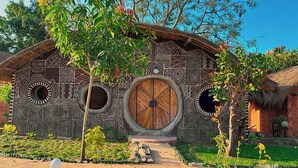 A building with circular wooden doors and patterned walls. - Wassado cultural lodging (Cap Skirring)