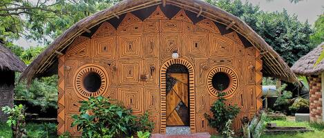 A traditional hut with geometric patterns, a central door, and a small porch area.