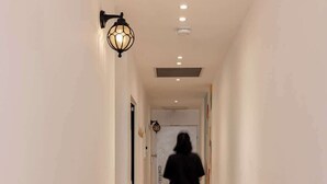 A hallway with wooden flooring and white walls, leading to a door at the end. - Stylish Beach Getaway  Steps from Carmel Market! (Tel Aviv-Yafo)
