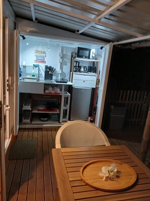 A compact kitchen with a microwave, coffee maker, and storage cabinets.