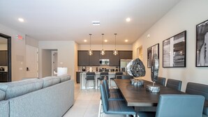 Una cocina moderna con armarios oscuros, una isla central e iluminación colgante.