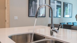 Una cocina moderna con lavamanos de acero inoxidable y un grifo cromado.