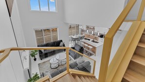 A spacious living area with a modern staircase, a kitchen, and a dining area. - 4 Bedrooms, 3 washrooms, and 2 living rooms, Luxury Home Close to Amenities (Leduc)