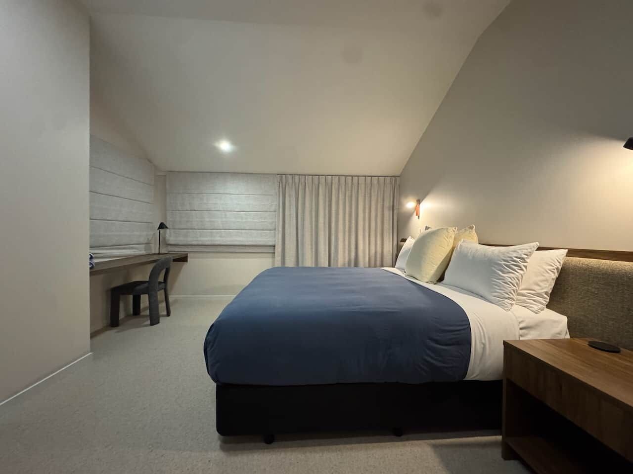Ein modernes Schlafzimmer mit Bett, Nachttisch und Schreibtisch.