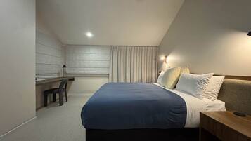 Ein modernes Schlafzimmer mit Bett, Nachttisch und Schreibtisch.