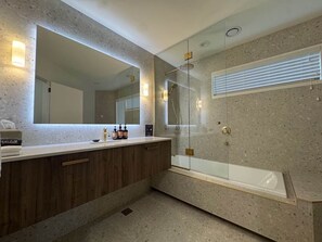 Ein modernes Badezimmer mit einem großen Spiegel, einer Badewanne und einer Duschkabine.