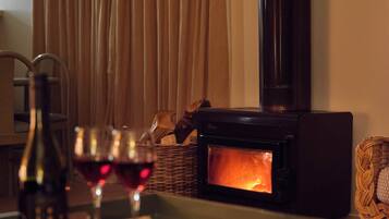 A cozy room with a fireplace, a bottle of wine, and glasses on a tray.