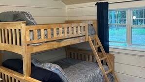 A bunk bed room with a window and a view of the outdoors. - Escape to Green Lake (Ellsworth)