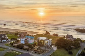 A coastal residential area with houses, a road, and a beach.