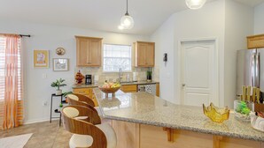 A modern kitchen with granite countertops, wooden cabinets, and stainless steel appliances. - 3 Mi to Escambia Bay: Home w/ Deck & Private Yard! (Milton)