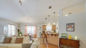 A spacious living area with a sofa, a dining table, and a kitchen in the background. - 3 Mi to Escambia Bay: Home w/ Deck & Private Yard! (Milton)