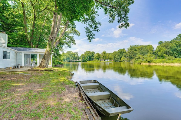 A lakeside cabin with a dock and a boat.