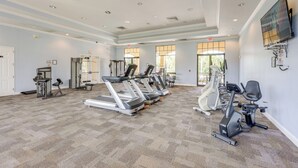Un'ampia palestra con tapis roulant, ellittiche e attrezzature per l'allenamento con i pesi.