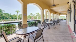 Veranda coperta con tavoli e sedie, vista piscina e cartello che indica divieto di fumare.