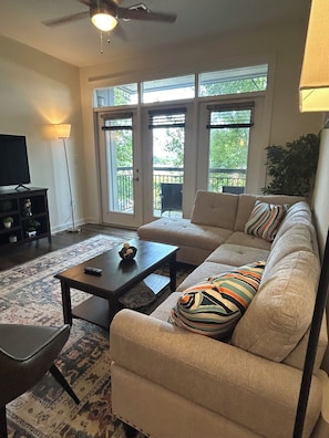 A living room with a sofa, coffee table, and a TV. - Spacious 2-Bedroom Apt, 5 minutes to Uptown (Charlotte)