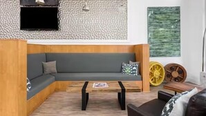 Una sala moderna con un sofá seccional, una mesa de centro y ruedas decorativas.