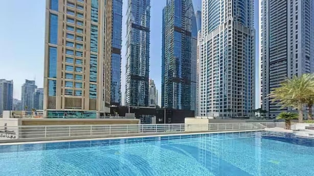 Une piscine avec vue sur les grands immeubles qui se dressent à l'arrière-plan.