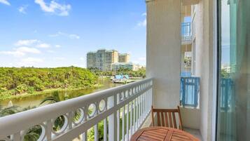 A balcony with a view of a river and buildings in the distance.