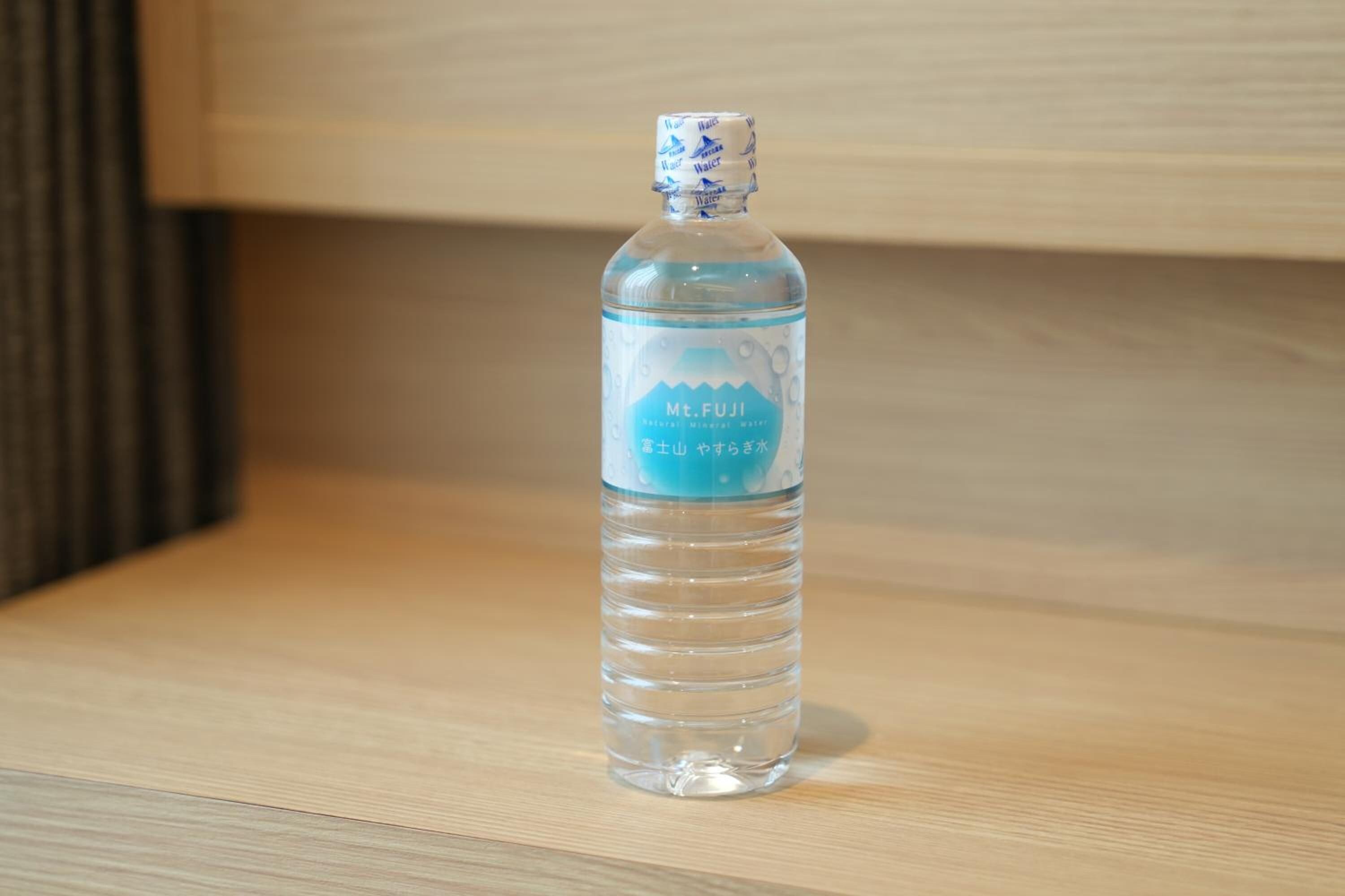 A clear water bottle with a label on a wooden surface.