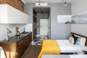 Une chambre moderne avec un lit, une table de chevet et une commode. Une fenêtre offre une vue sur un paysage enneigé.