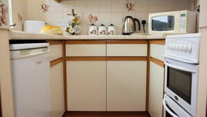 A compact kitchen with a microwave, kettle, and a dishwasher. - The Stable, Aberystwyth (Aberystwyth)