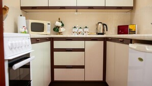 A compact kitchen with a microwave, a kettle, and a toaster.