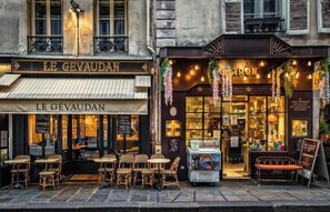 A café named LE GÉVAUDAN with outdoor seating and a chocolate display.