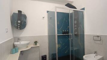Ein modernes Badezimmer mit einer Duschkabine aus Glas, einem Waschbecken und einem Bidet.