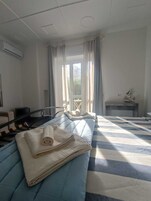 Una camera d'albergo con un letto, una scrivania e una finestra con tende.