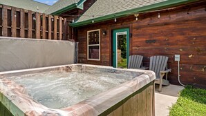 A wooden cabin with a hot tub, two Adirondack chairs, and a green door. - Close to Dollywood-Hot Tub & Kids Closet (Pigeon Forge)